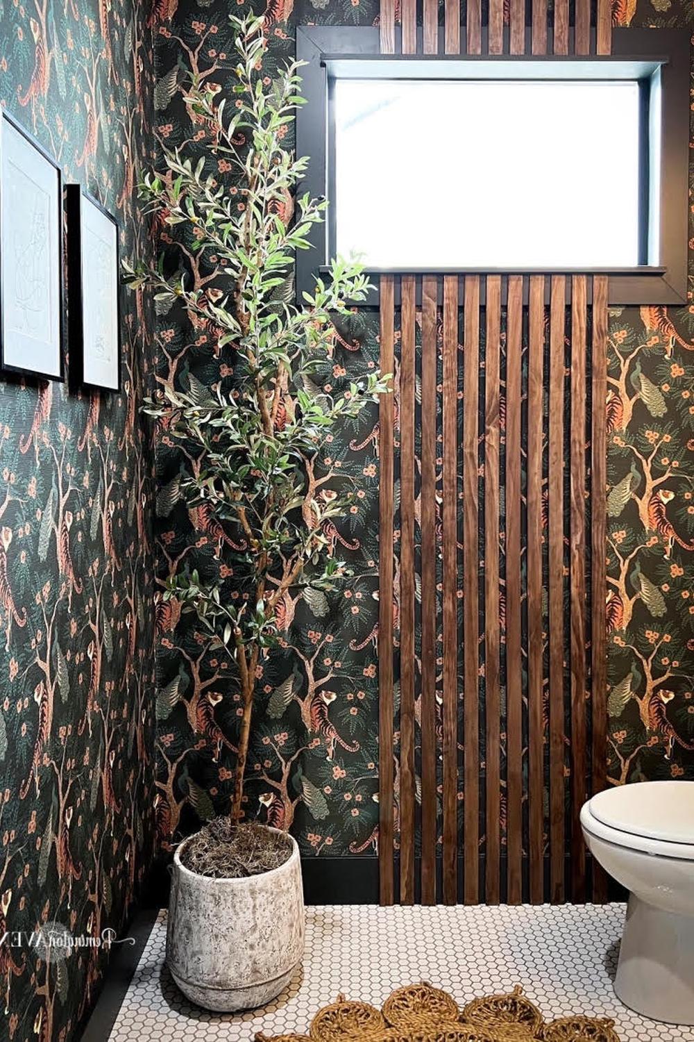 Baño elegante con papel pintado oscuro botánico y elementos naturales