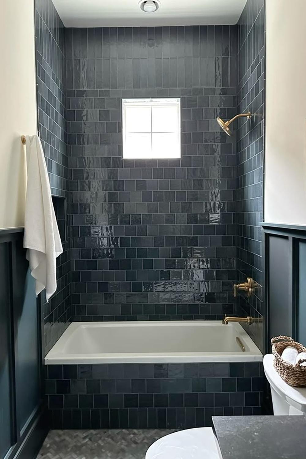 A moody blue bathroom with glossiness and warm accents.