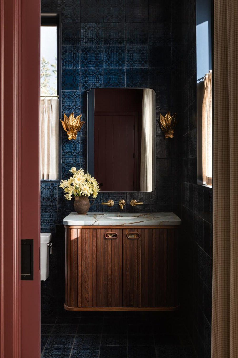 A luxurious moody blue bathroom featuring textured tiles and elegant fixtures.