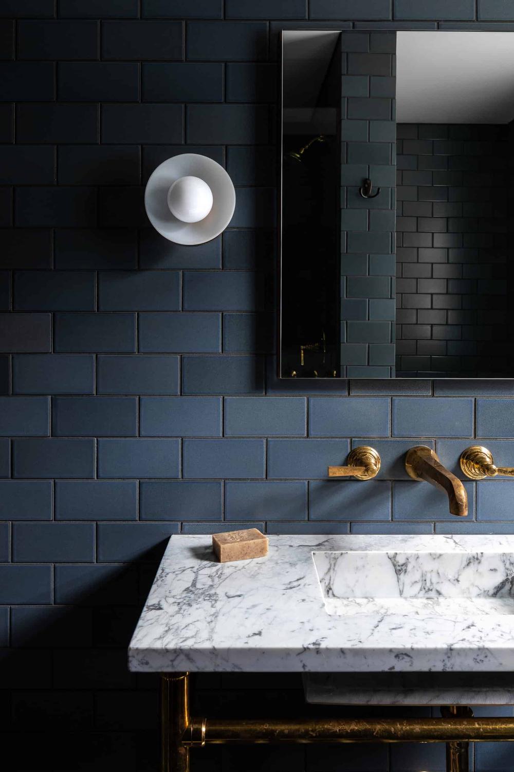 A modern moody blue bathroom with charming floral patterns and elegant fixtures.