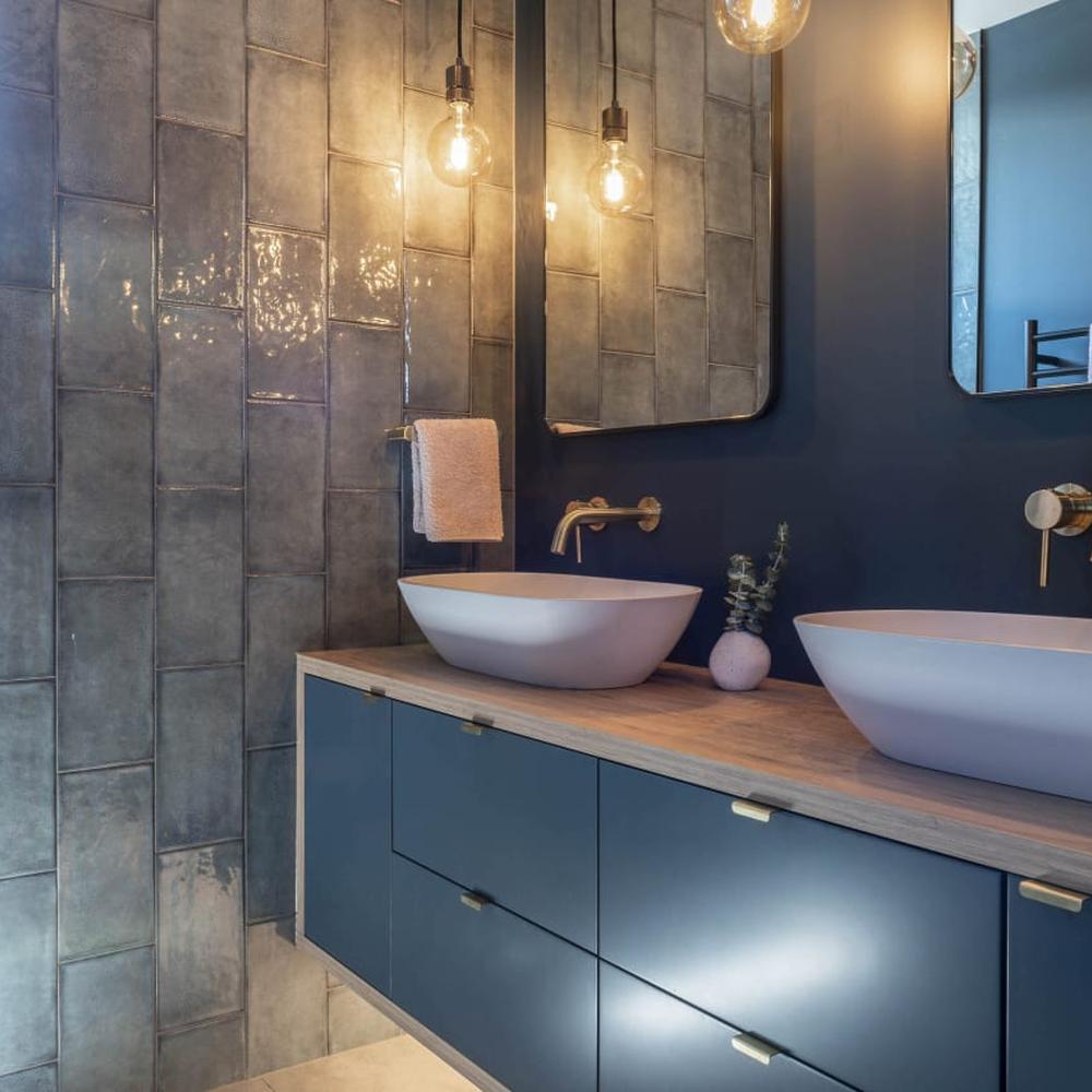 An effortlessly stylish moody blue bathroom featuring soft colors and elegant fixtures.