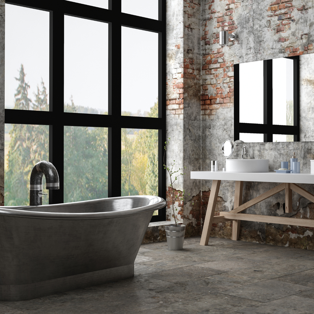 A modern industrial bathroom featuring a sleek freestanding tub and exposed brick.