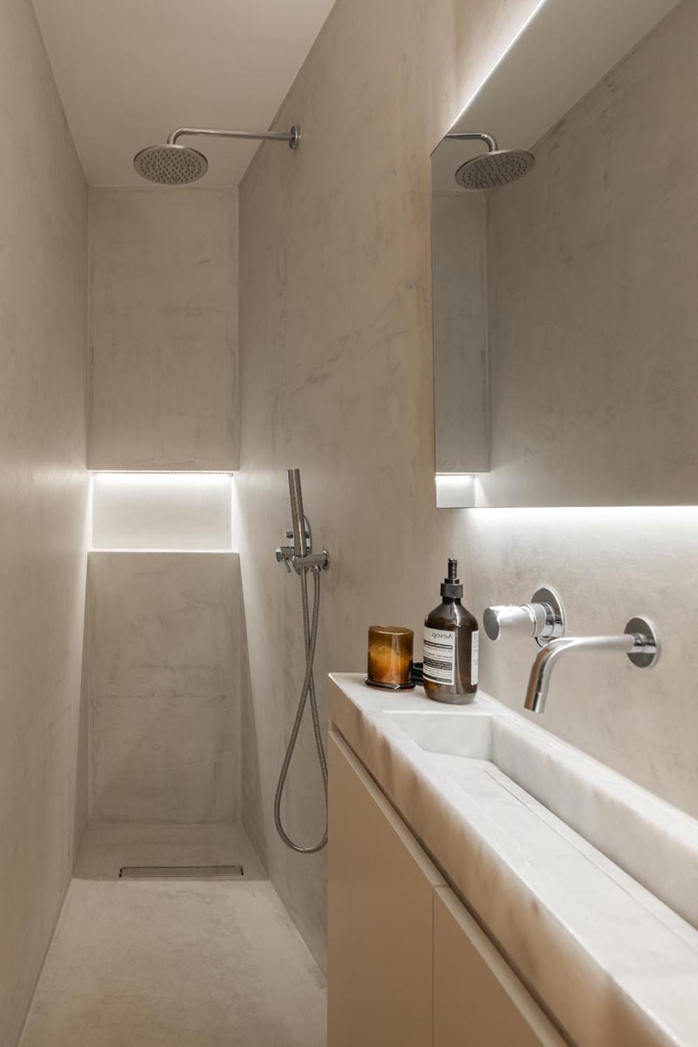 Minimalist narrow bathroom with light-colored concrete finishing and stylish fixtures
