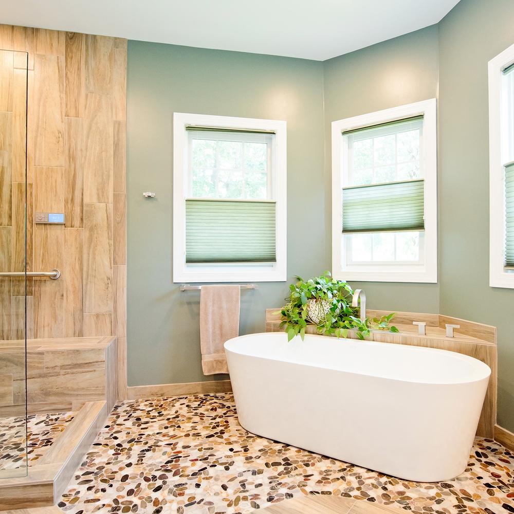 A pebble stone finish floor and warm textiles in a bathroom