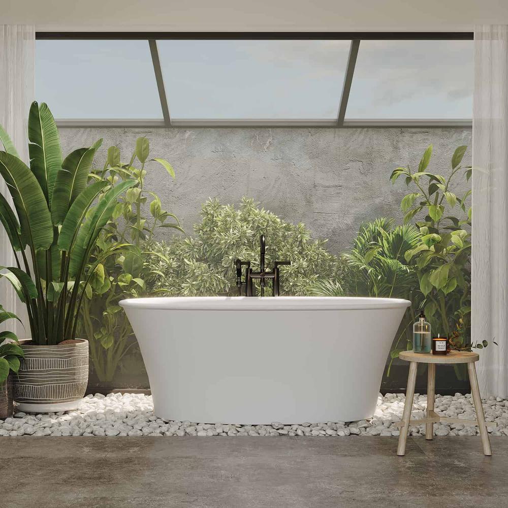 A modern, serene bathroom with a glass wall, freestanding bathtub and lush greenery
