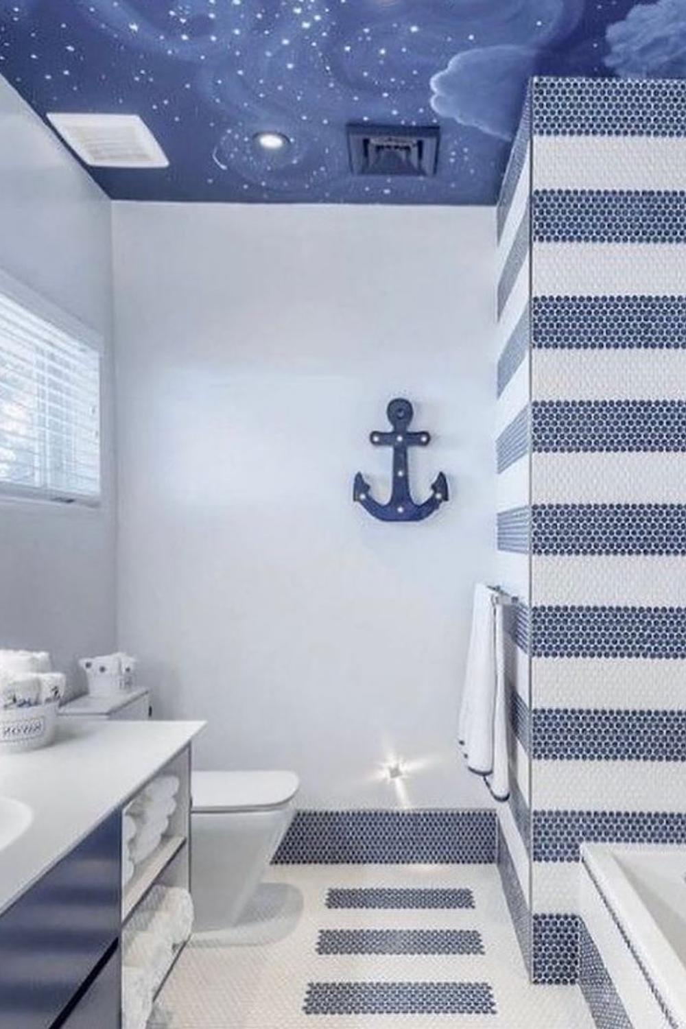 Baño náutico con techo azul y decoración de anclas