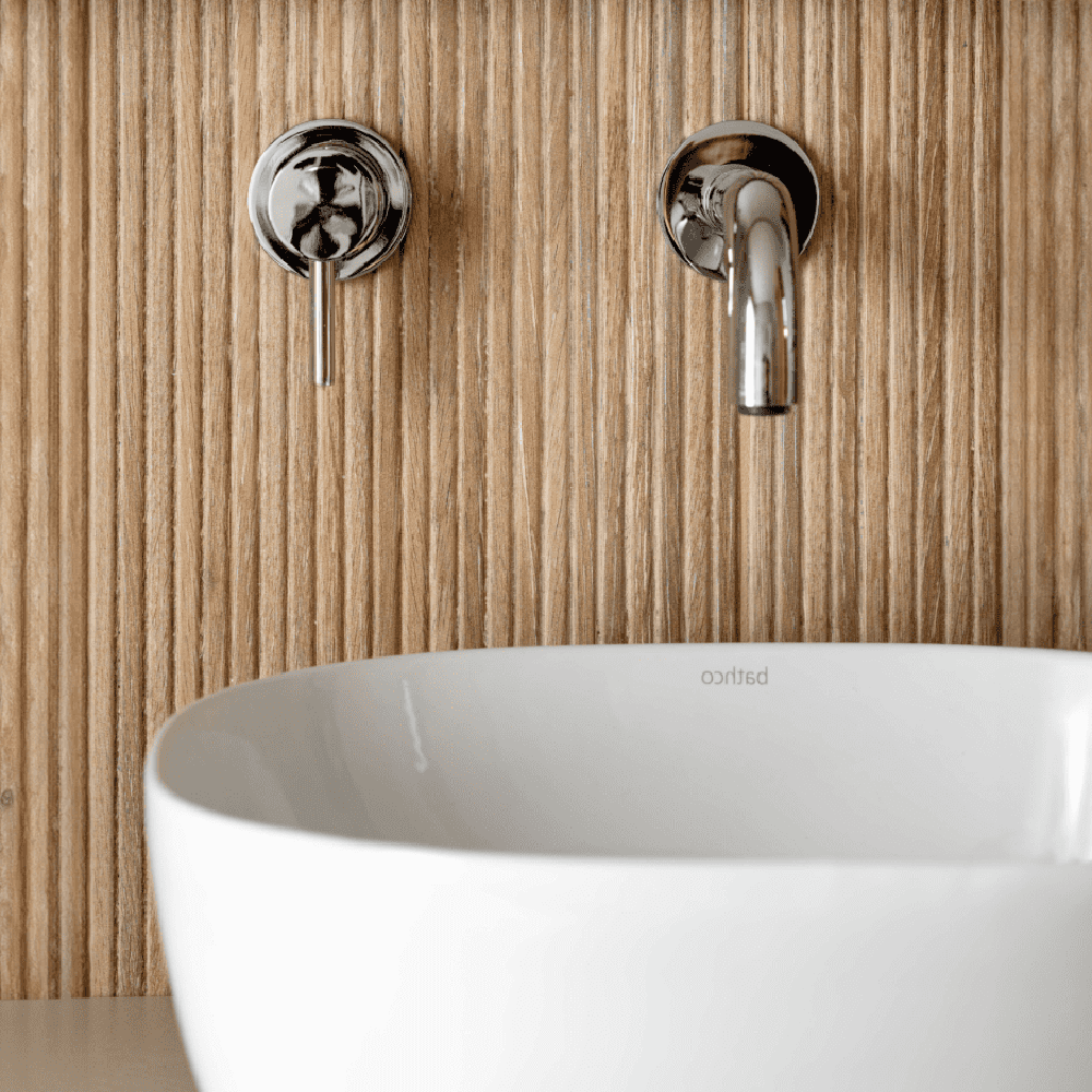 Modern bathroom with a textured wood-like wall and round white basin.