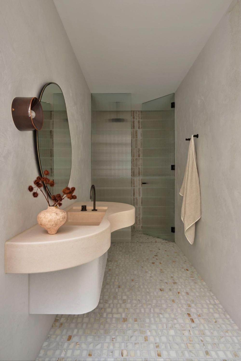 Modern minimalist bathroom featuring soft greys and whites with a unique sink design.
