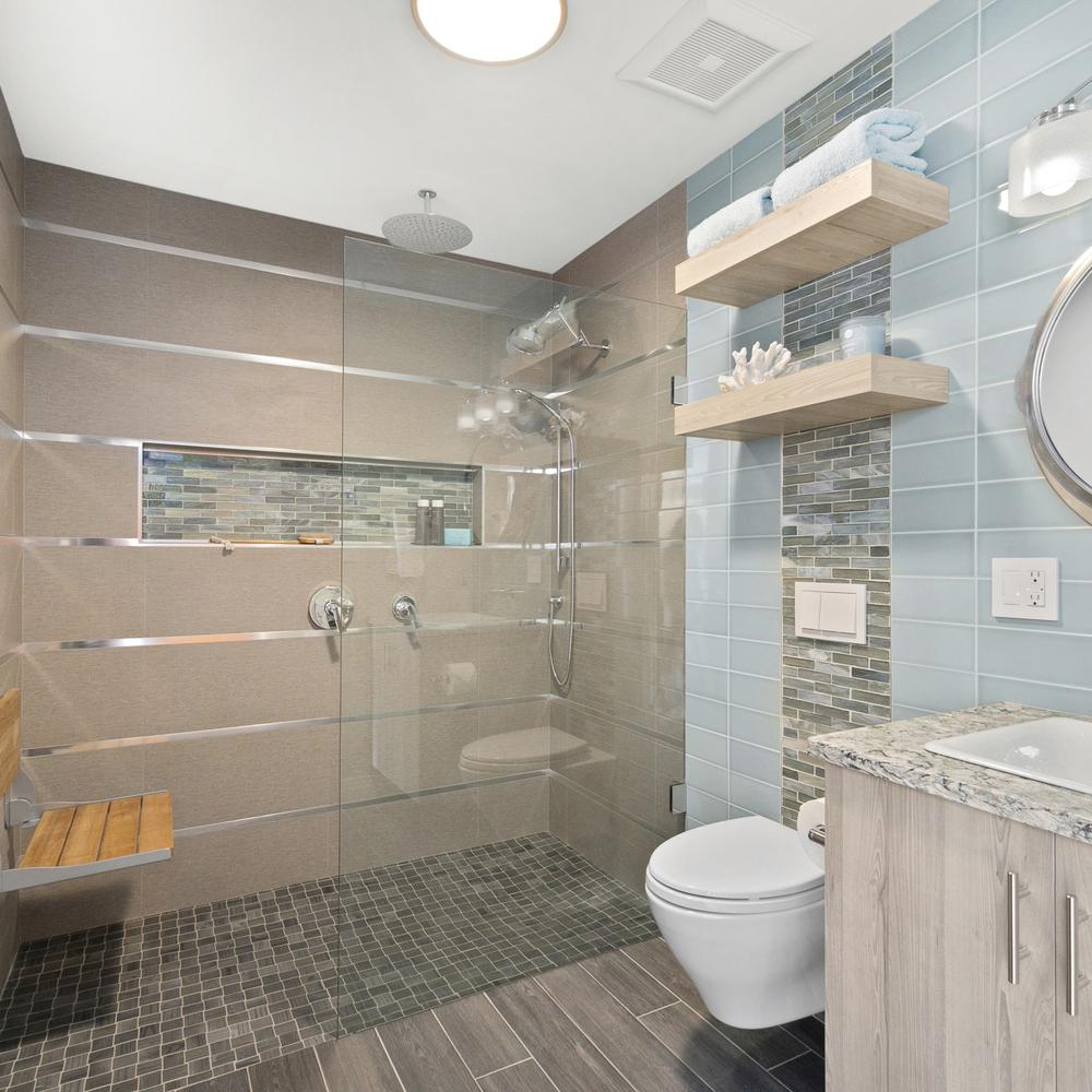 A modern bathroom featuring a glass-enclosed shower and beach-inspired tiles.