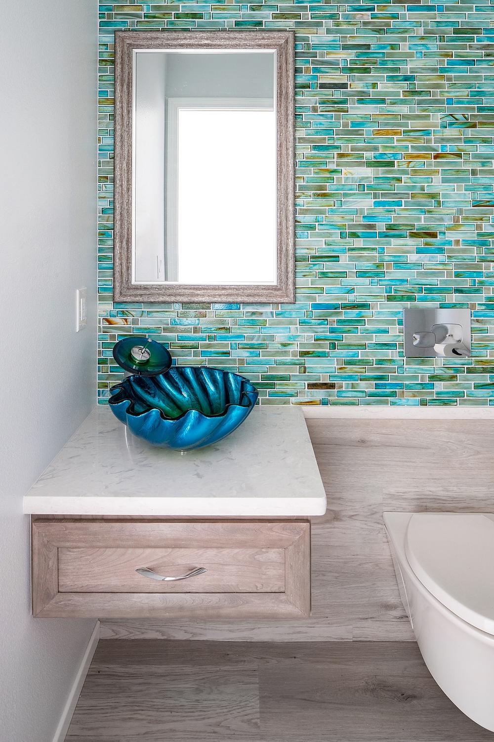 A bathroom showcasing mosaic tiles in ocean colors and contemporary decor.