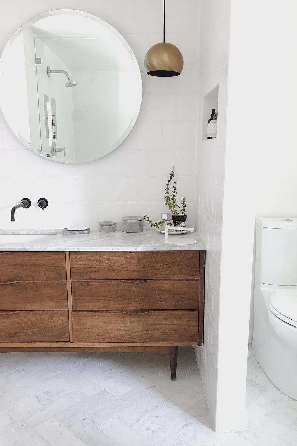 Rinconera de lavabo con acabados en madera cálida y grifería color negro mate