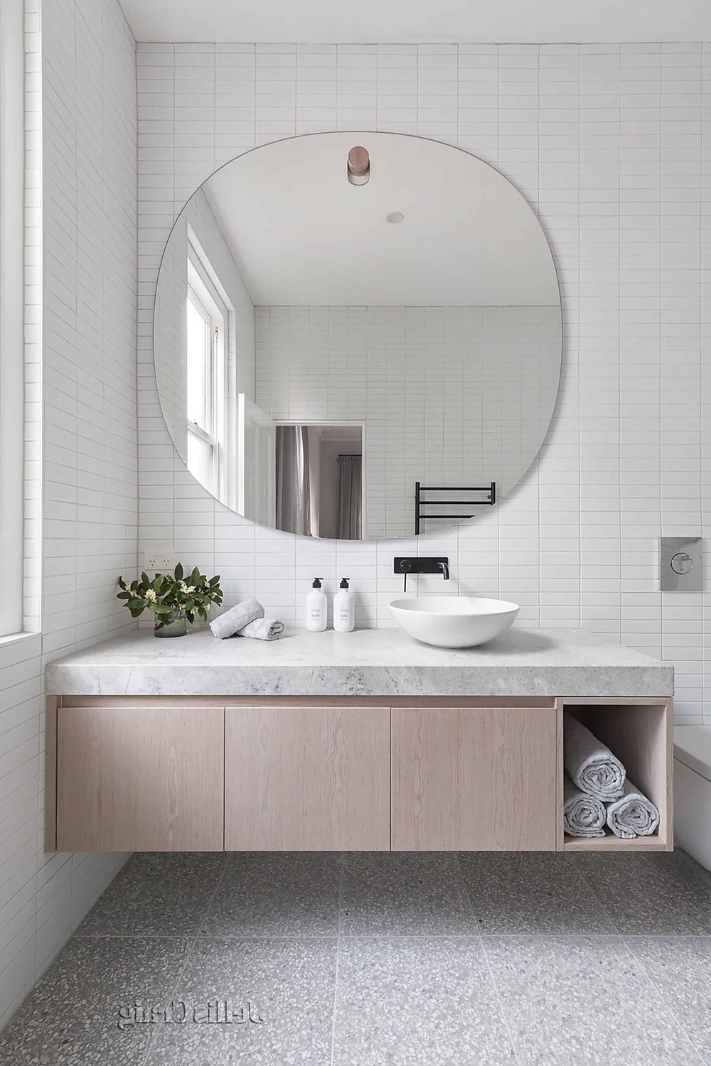 Rinconera de lavabo moderna con lavabo de piedra y acabados en madera clara