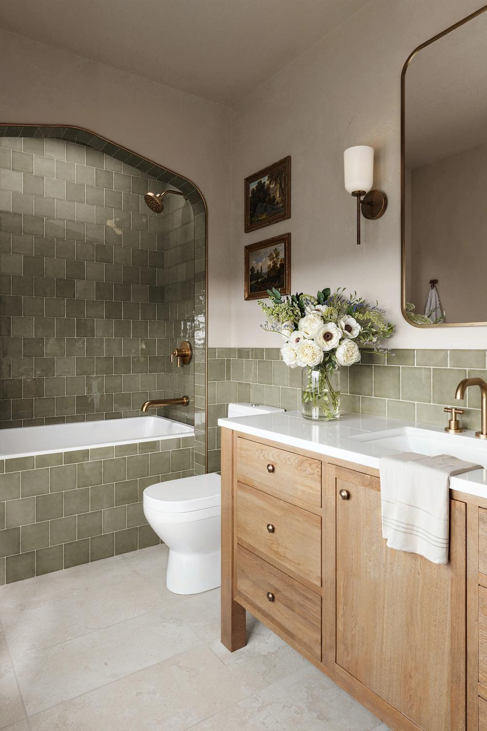 A bathroom featuring a shower and bathtub surrounded by olive green tiles.