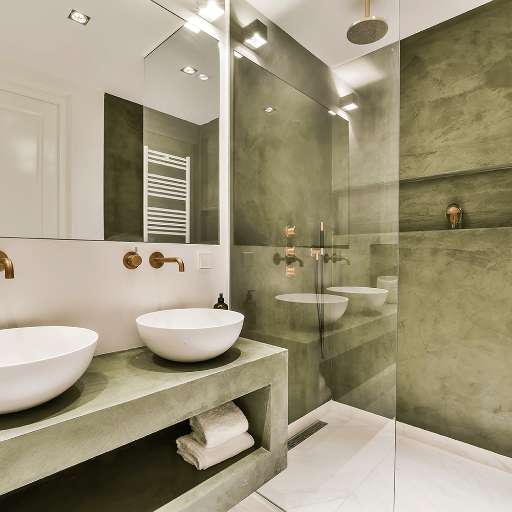 A sleek bathroom with a minimalist double vanity and olive green accents.