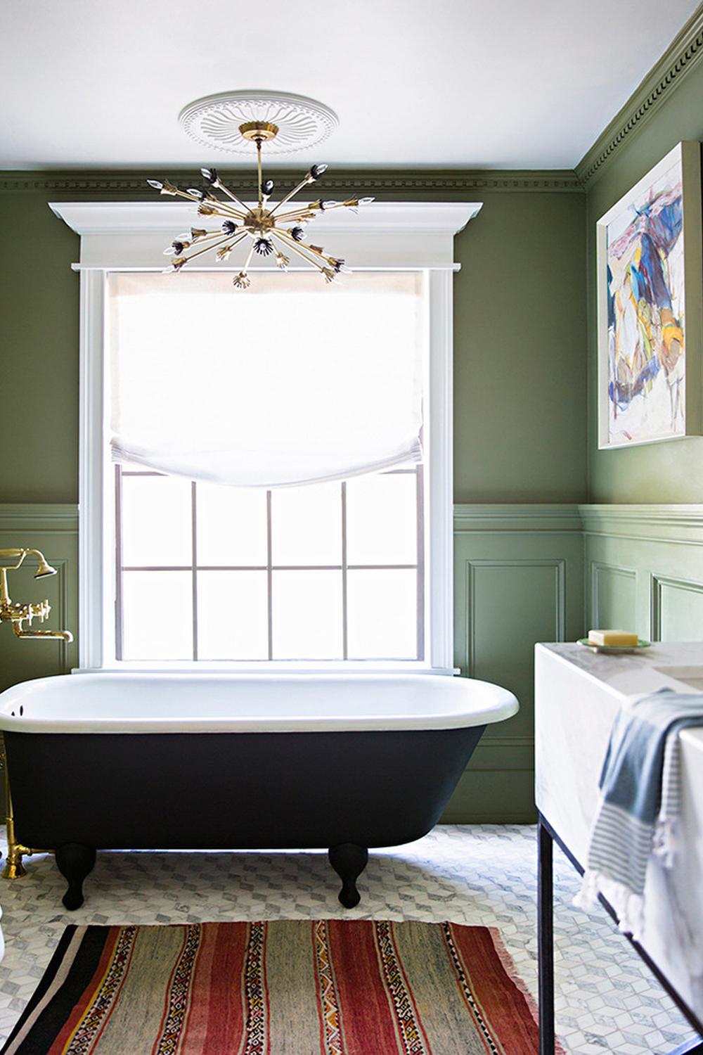A cozy bathroom featuring a vintage freestanding bathtub in olive green and warm tones.