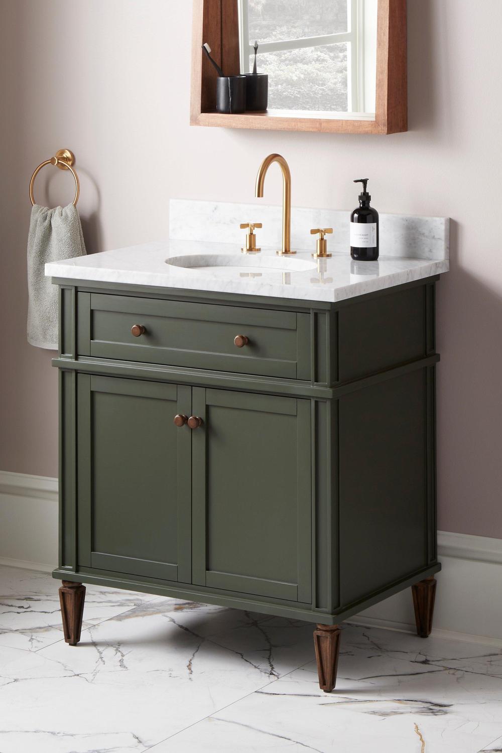 A fresh modern bathroom design featuring olive green vanities and warm woods.