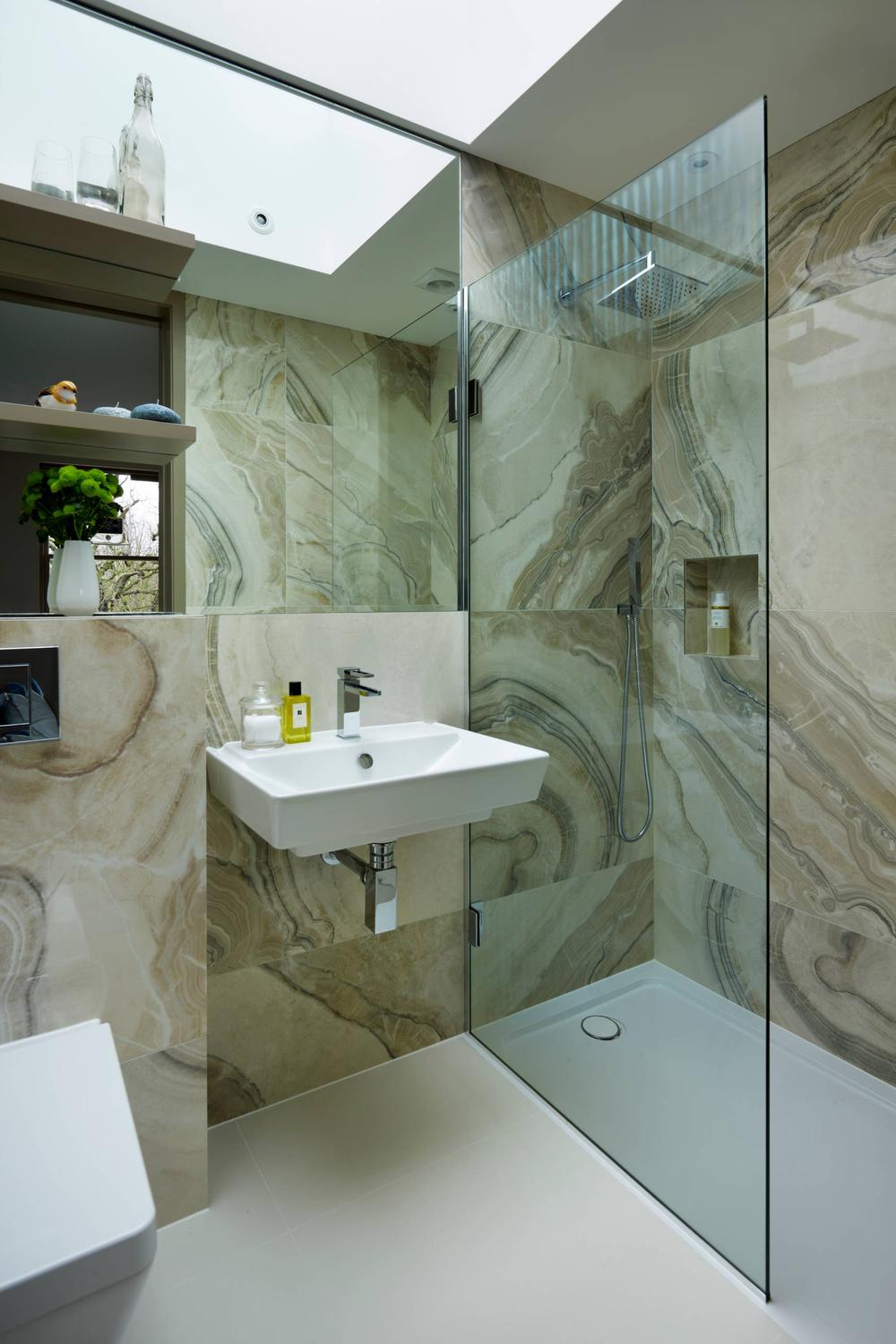 Baño lujoso con azulejos de ónix y juego de luces natural