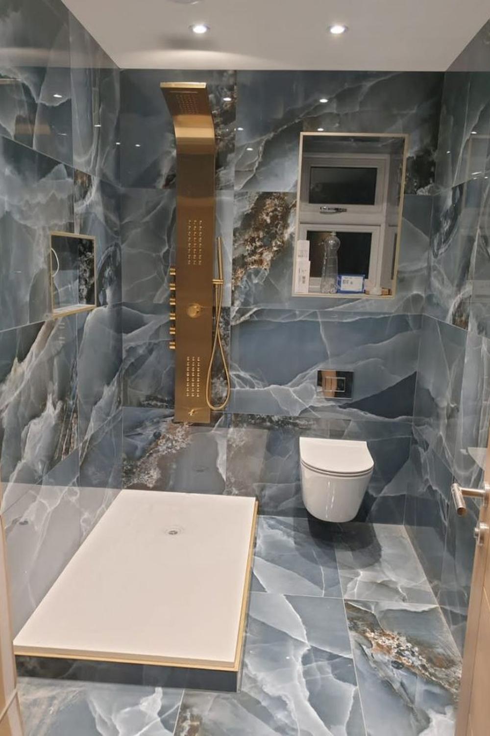 Baño elegante con azulejos de ónix que destaca por sus detalles sutiles de diseño