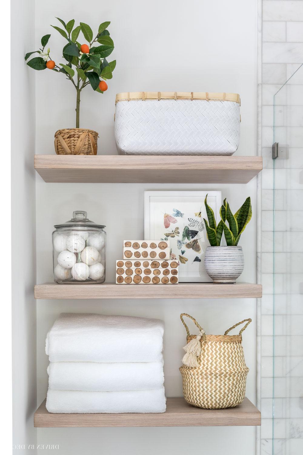 Estanterías abiertas decoradas con plantas y arte en un baño moderno