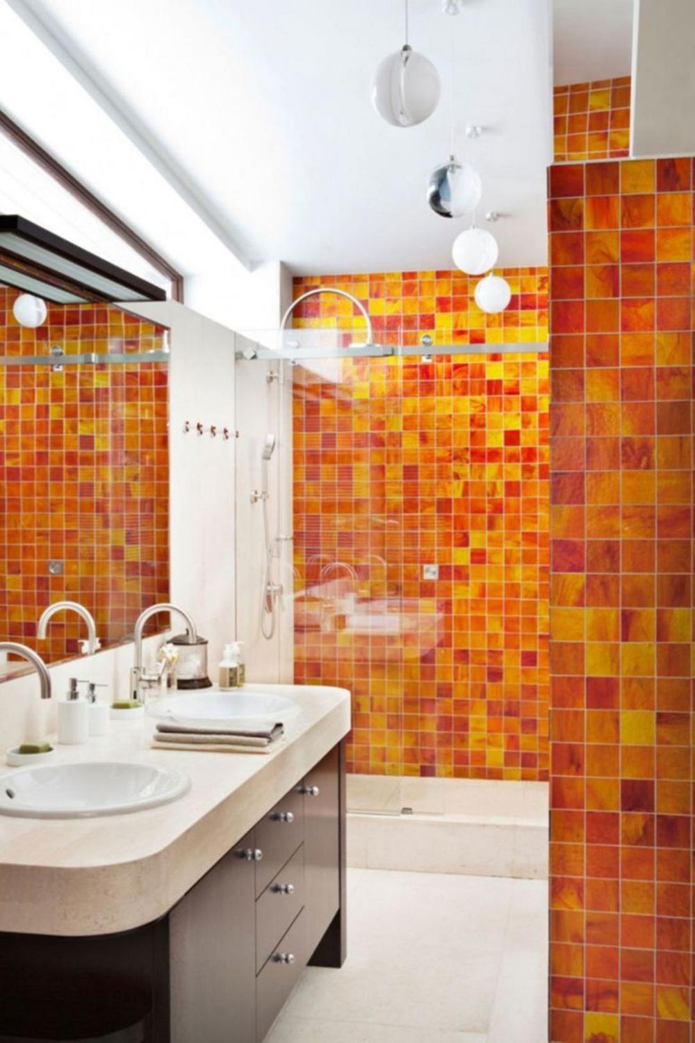 A vibrant bathroom with mosaic-like orange tiles creating a warm atmosphere.