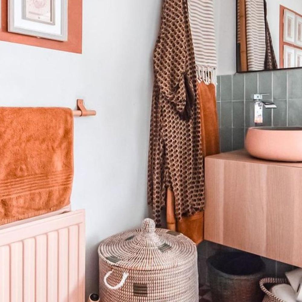 A stylish boho bathroom featuring warm oranges and earthy tones.