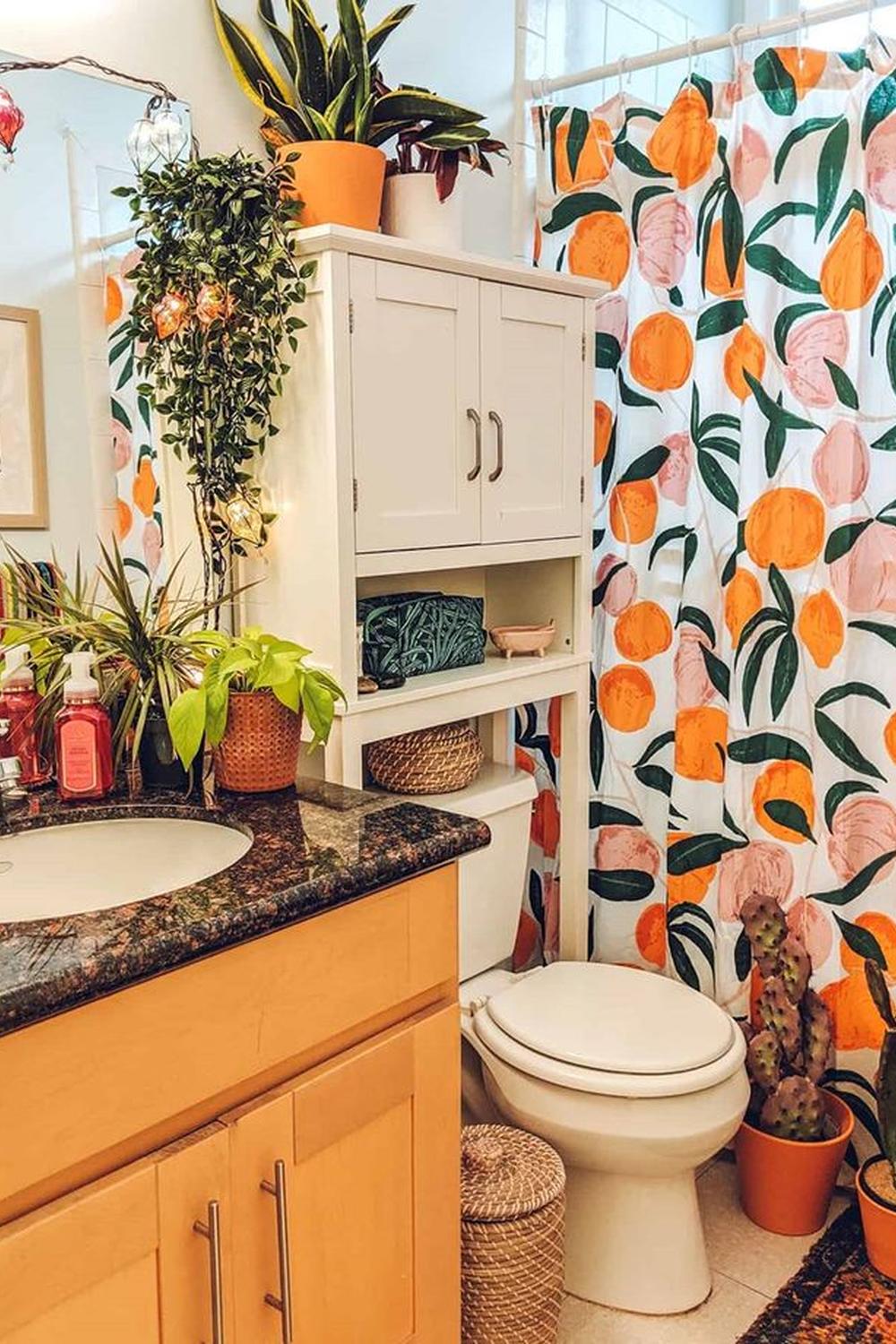 A colorful bohemian bathroom featuring an abstract fruit shower curtain and multiple green plants.