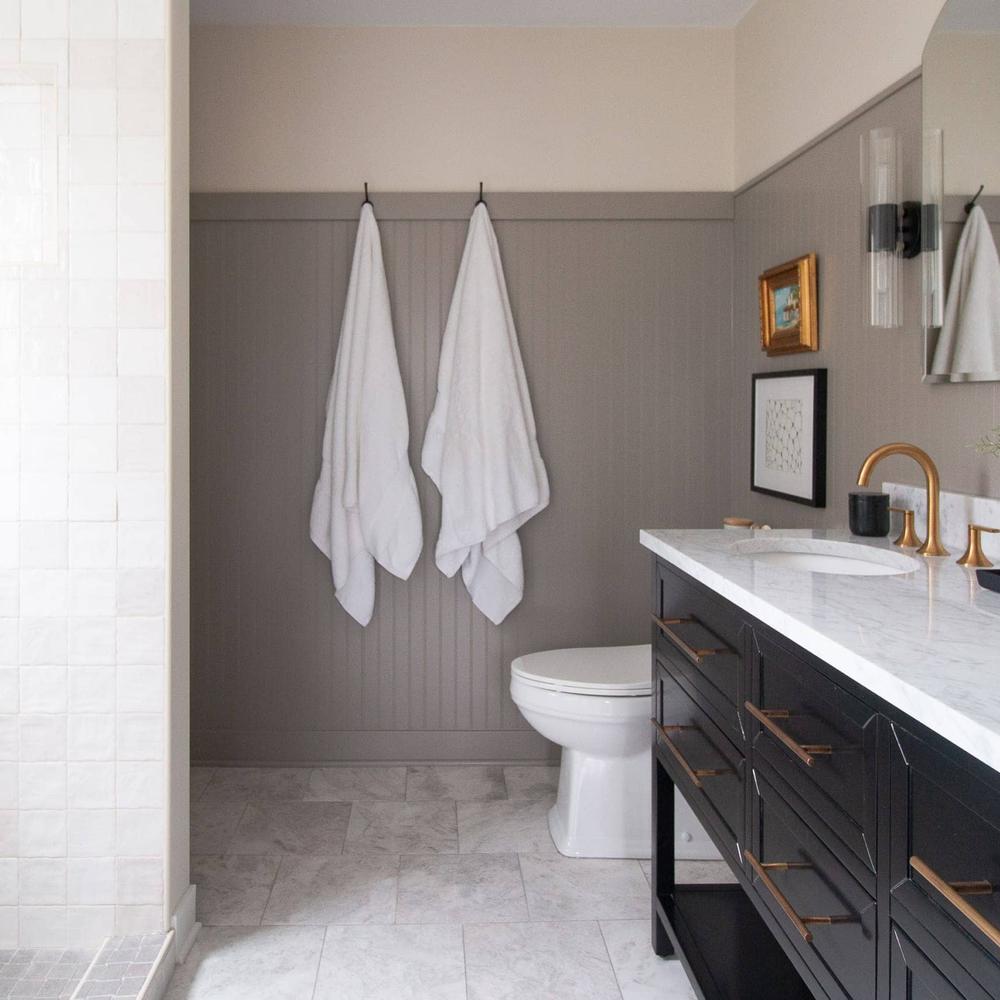 Baño con tonos grises y mármol blanco