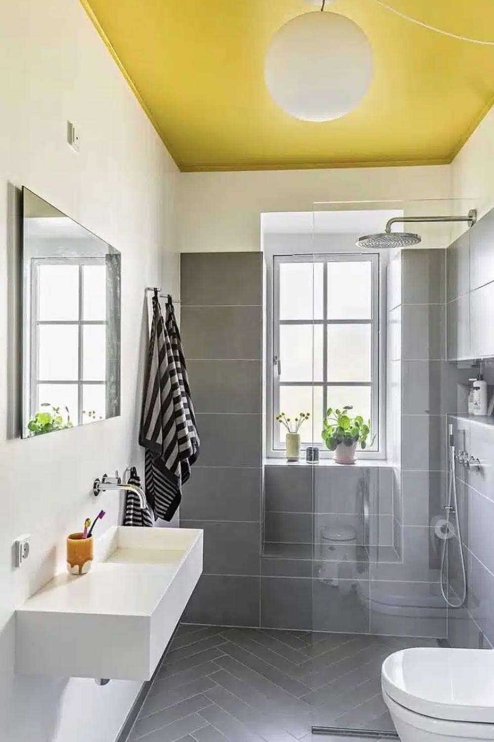 Baño con techo amarillo y diseño minimalista