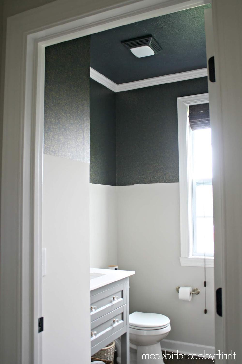 Baño moderno con techo azul oscuro y decoración luminosa