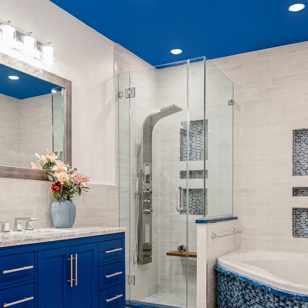 Baño moderno con techo azul brillante y muebles azules