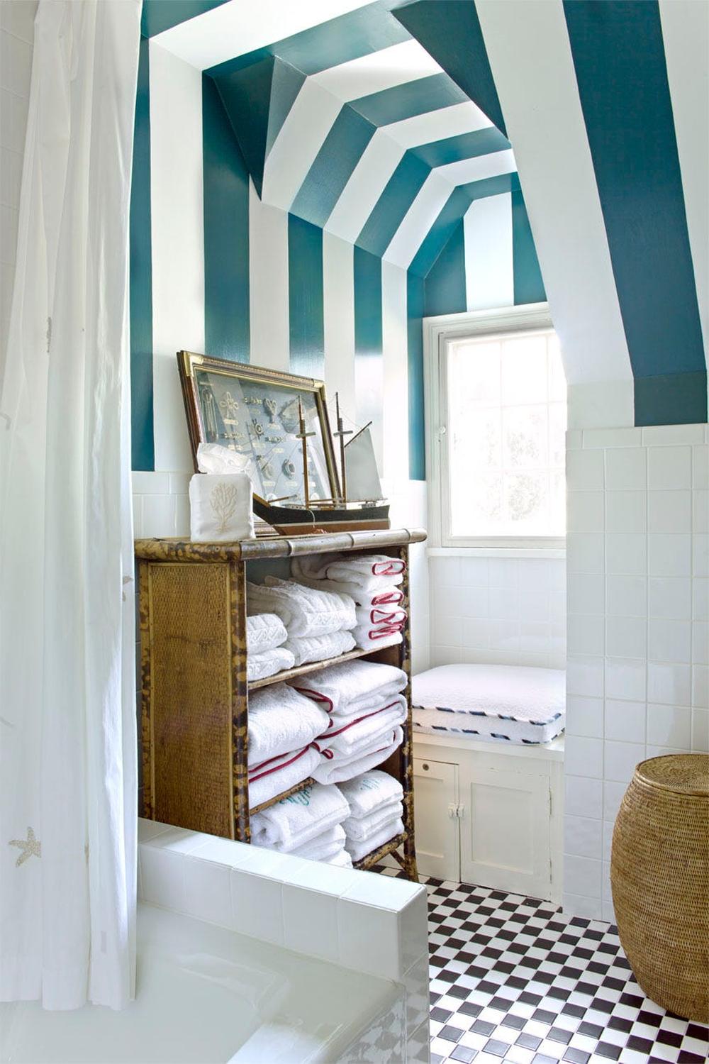 Baño con techo de rayas diagonales y estilo náutico