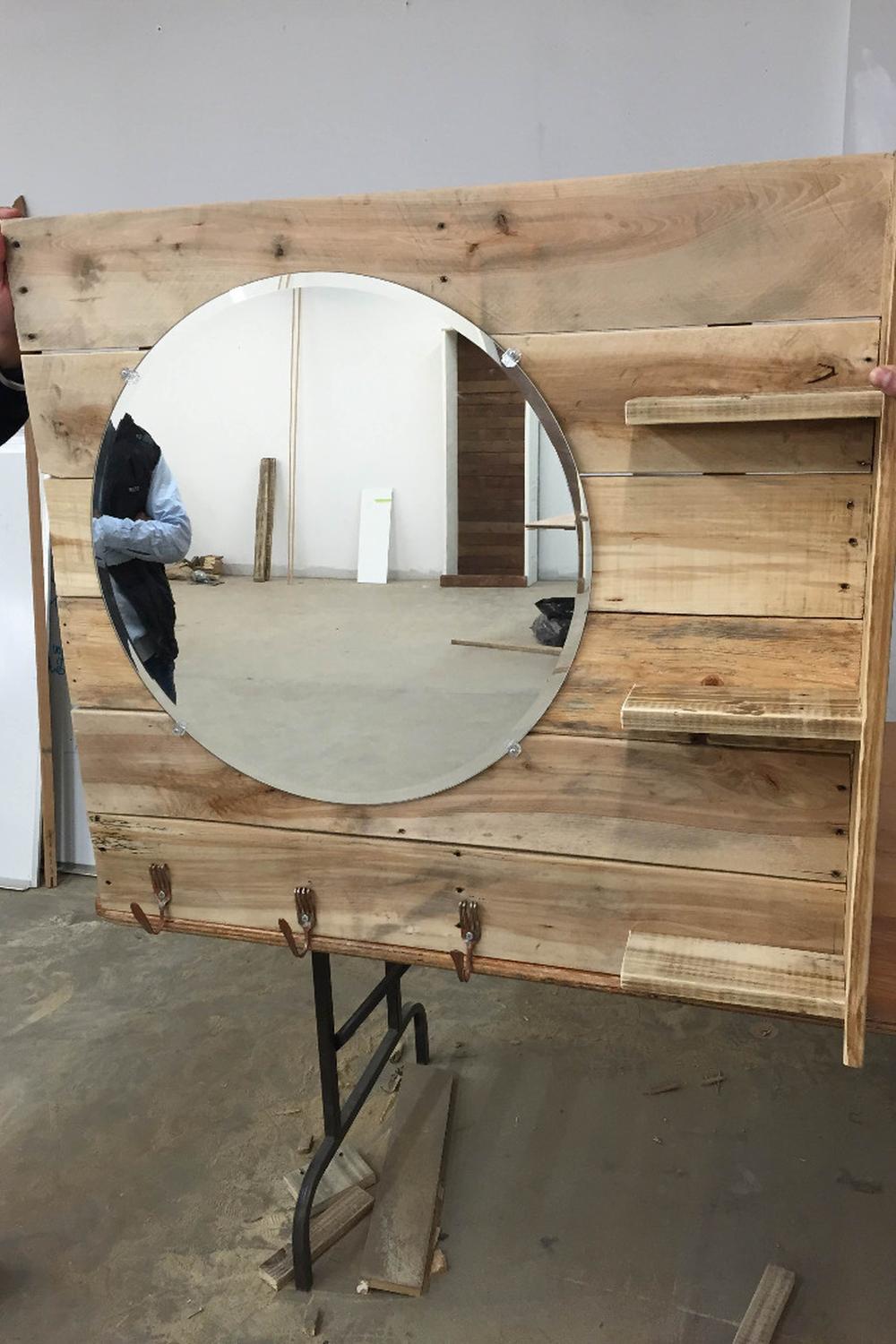 Lavabo de palets con espejo redondo y estantes añadidos