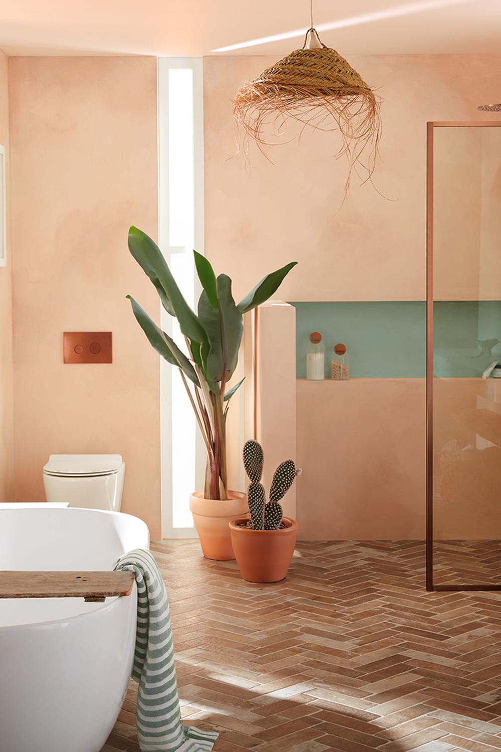 Modern bathroom featuring soft peach tiles and rich brown herringbone flooring
