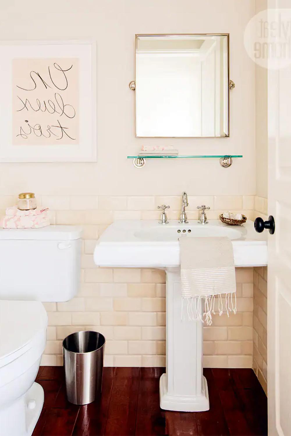 Bathroom with light peach tiles and dark wooden flooring