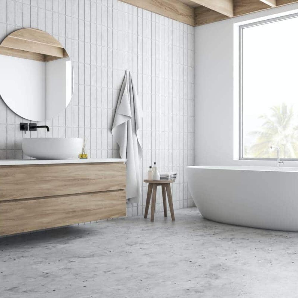 Diseño de paredes con azulejos texturizados en gris perla, creando un baño moderno y elegante