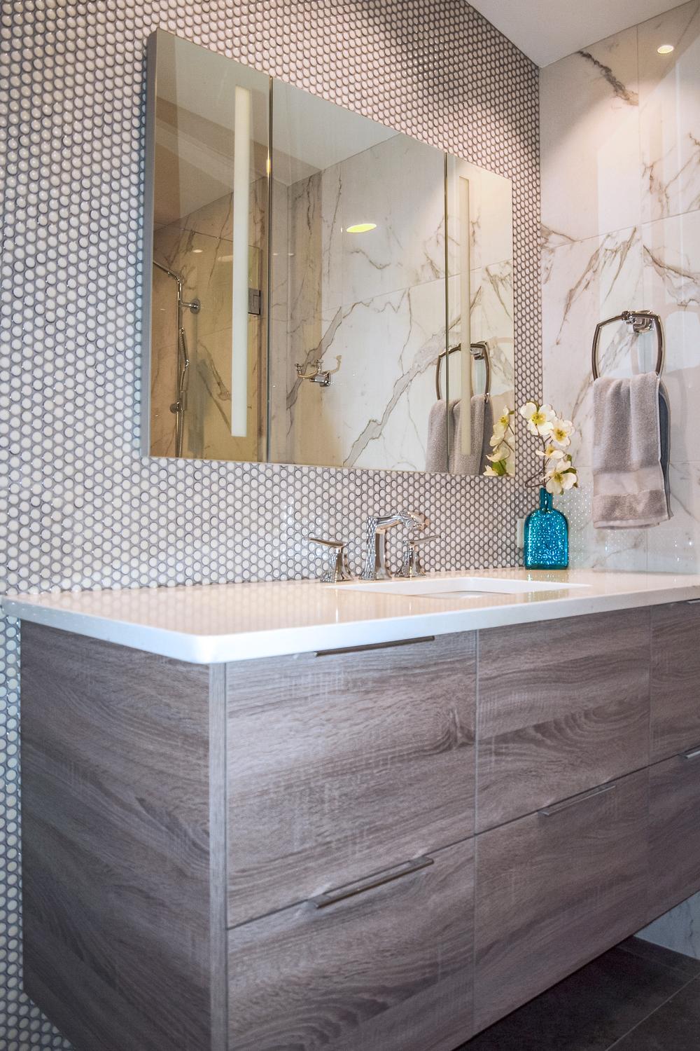 A classic bathroom design featuring a double sink vanity with penny tile accents.