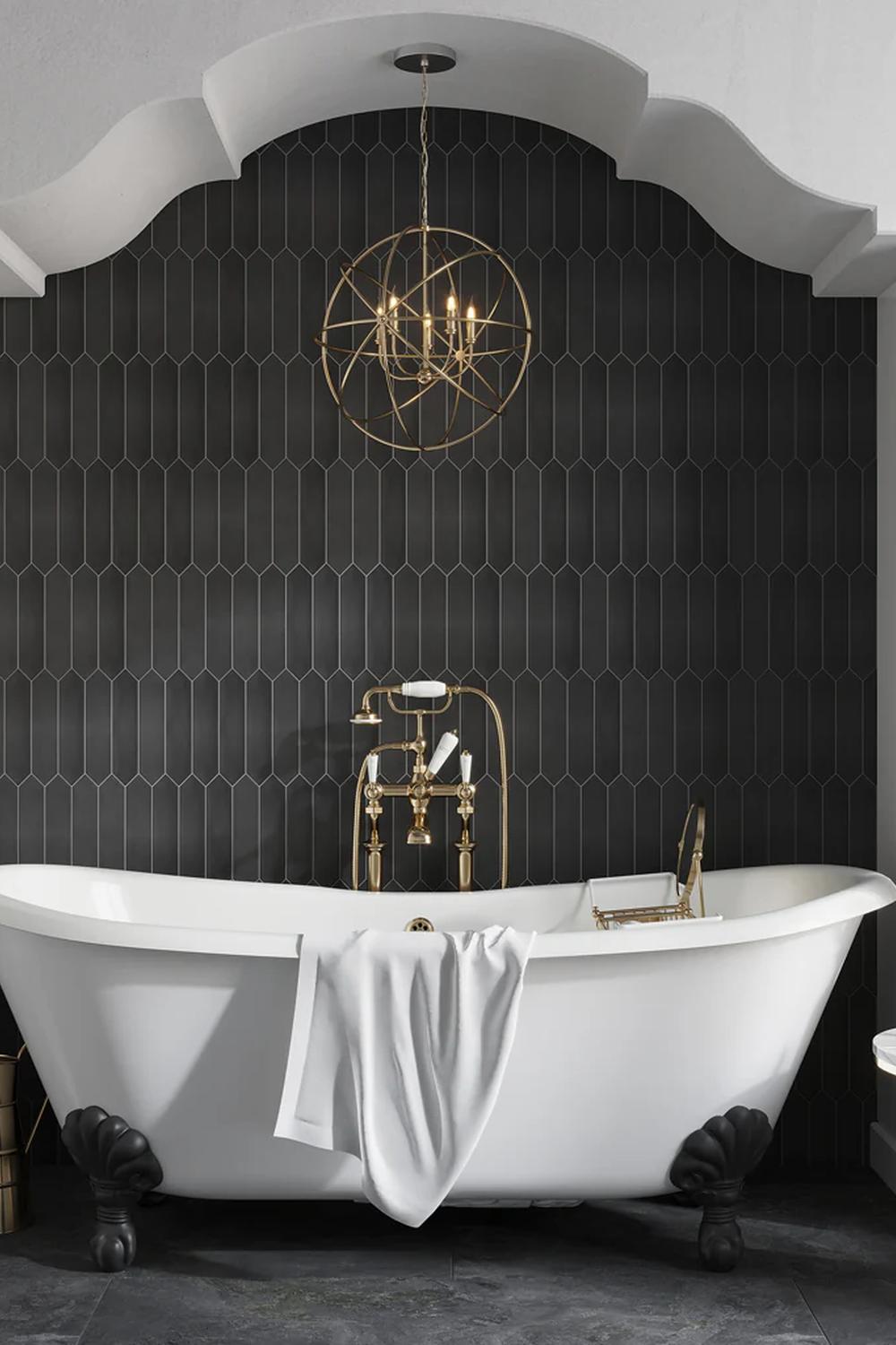 Stylish bathroom featuring a clawfoot tub against a backdrop of dark picket tiles, creating an inviting and luxurious atmosphere.