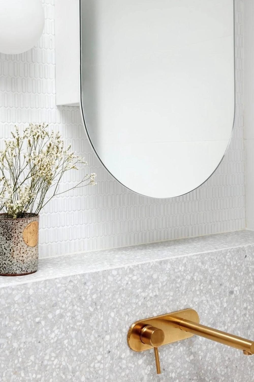 Modern bathroom featuring glossy picket tiles and matte gold accents, creating a seamless blend of functionality and aesthetics.