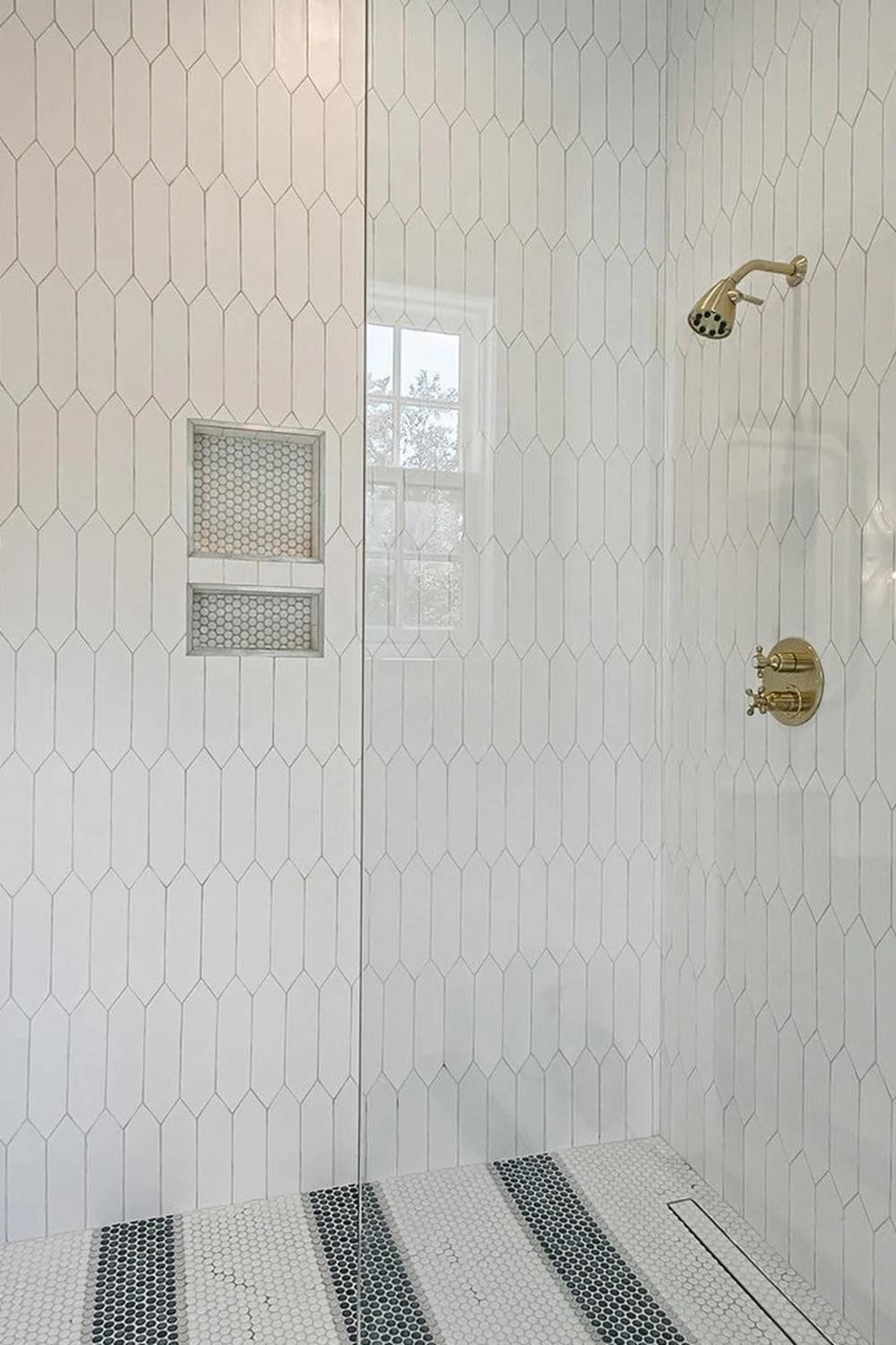 Sleek modern shower with elongated picket tiles and gold fixtures, creating an inviting and functional design.