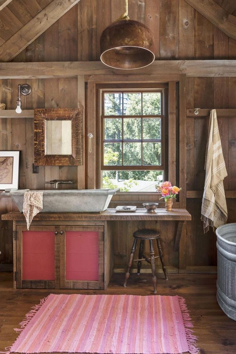 Rustic bathroom with wooden paneling and pink accents.