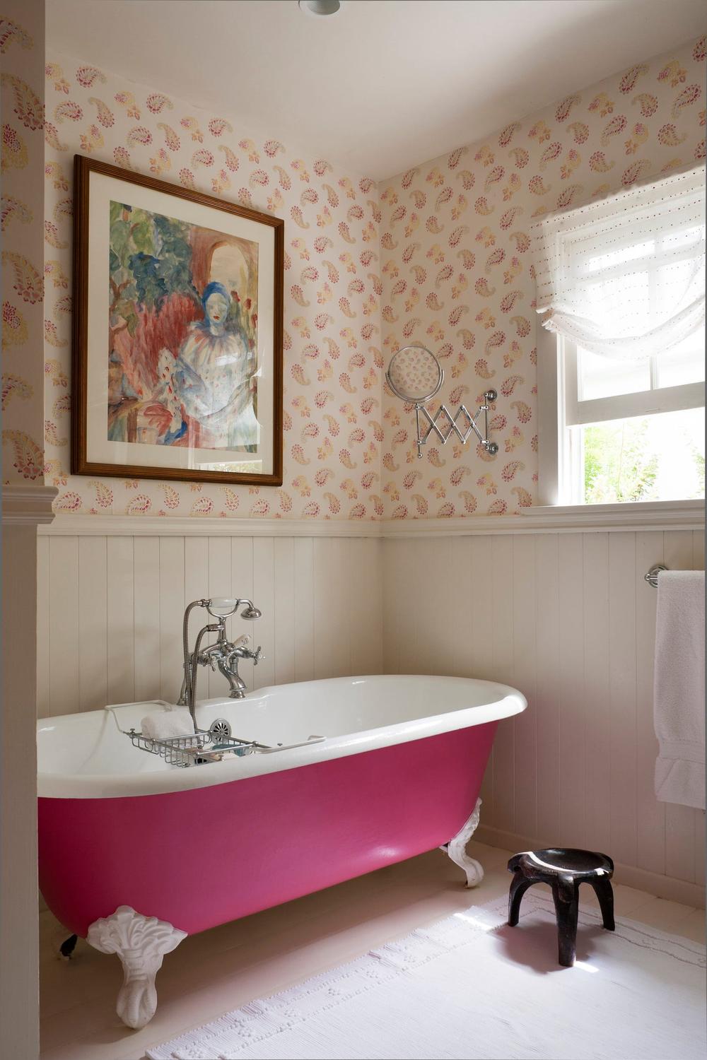 Charming rustic bathroom with vibrant floral wallpaper and cozy accessories.