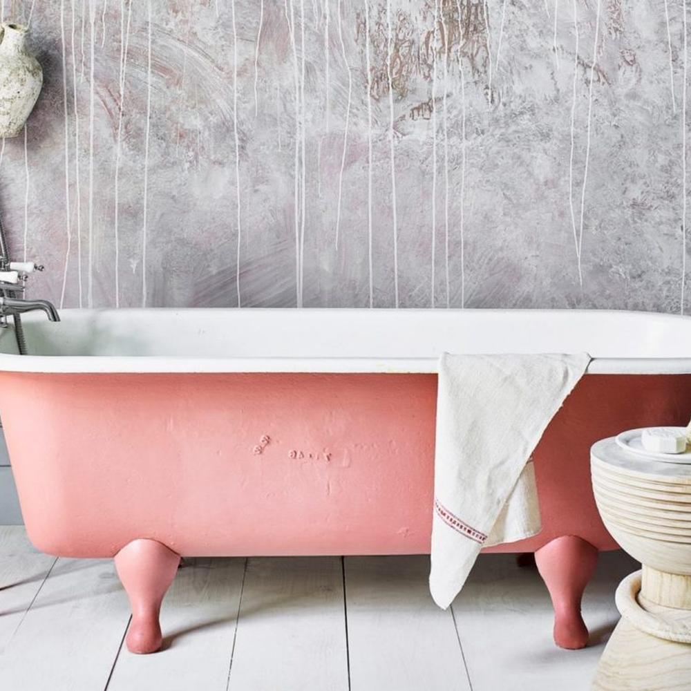 Pink rustic bathroom featuring a clawfoot tub with elegant decor.