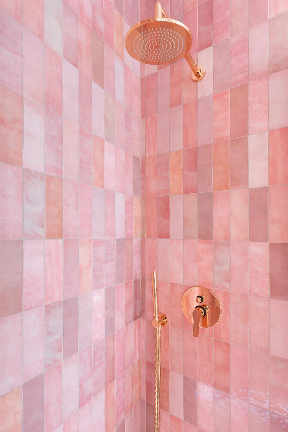 Baño elegante con azulejos rosas que destacan en un diseño moderno.