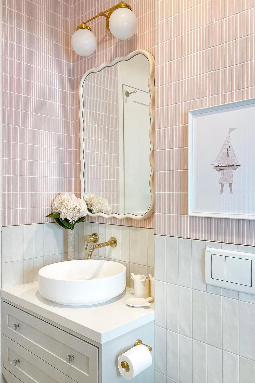 Baño moderno con azulejos rosas y detalles elegantes que resaltan.