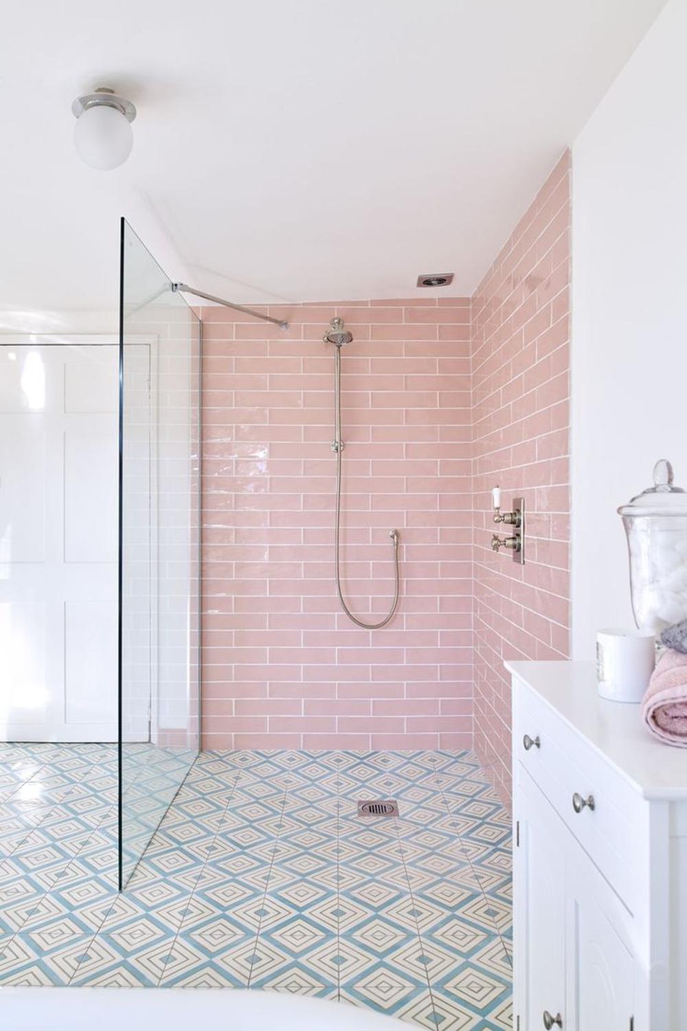 Baño moderno con azulejos rosas y detalles elegantes que resaltan.