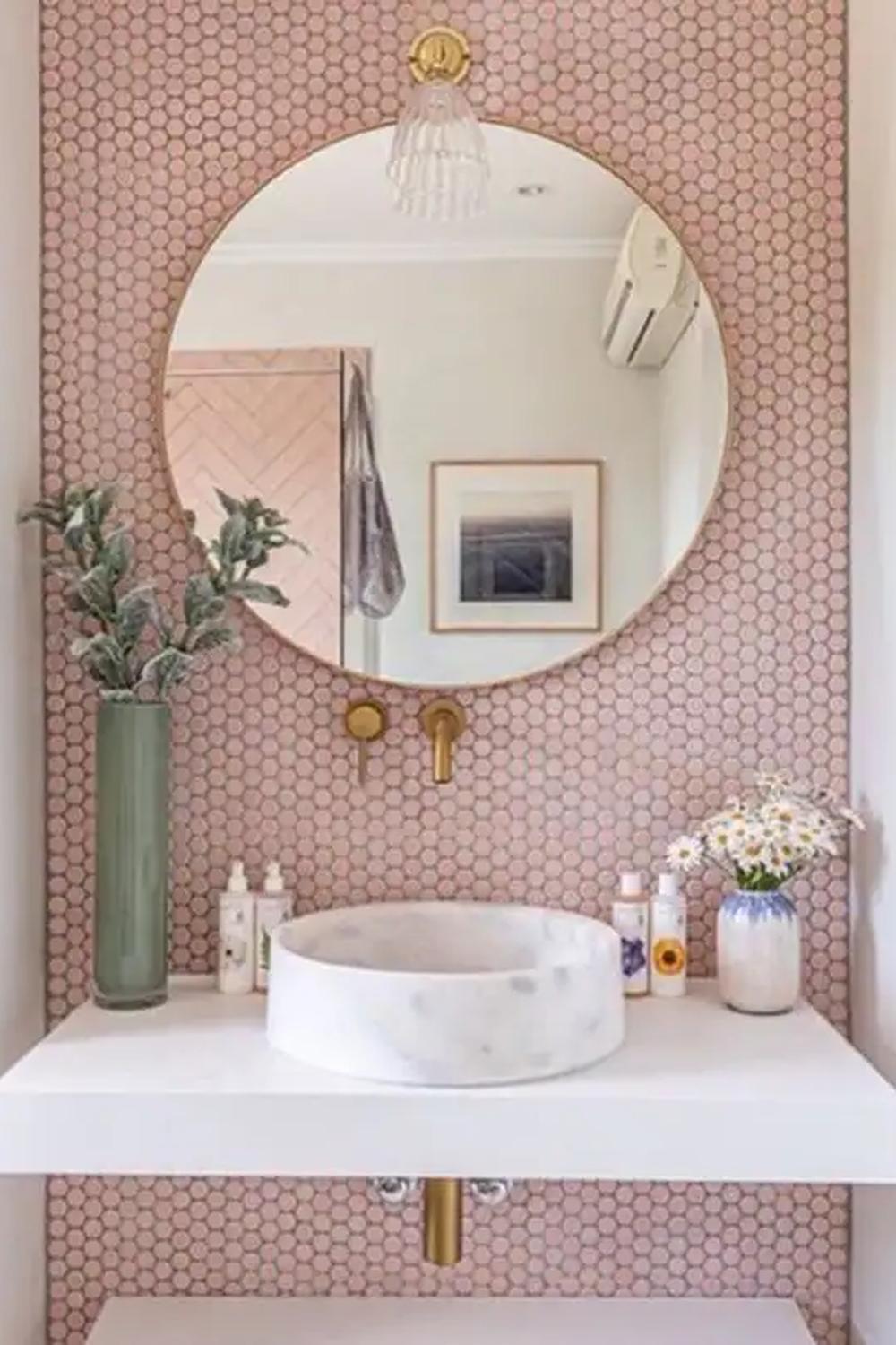 Baño estiloso con azulejos rosa en un patrón elegante que ilumina el espacio.