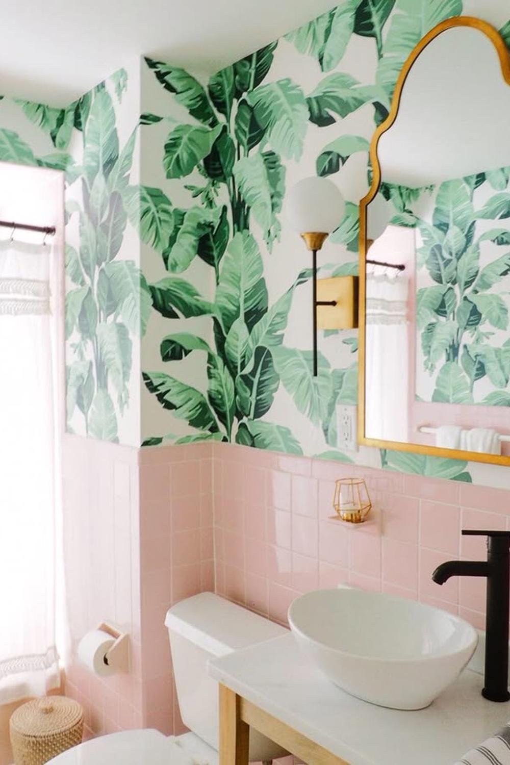 Baño moderno con azulejos rosas y un toque de vegetación que mejoran el entorno.