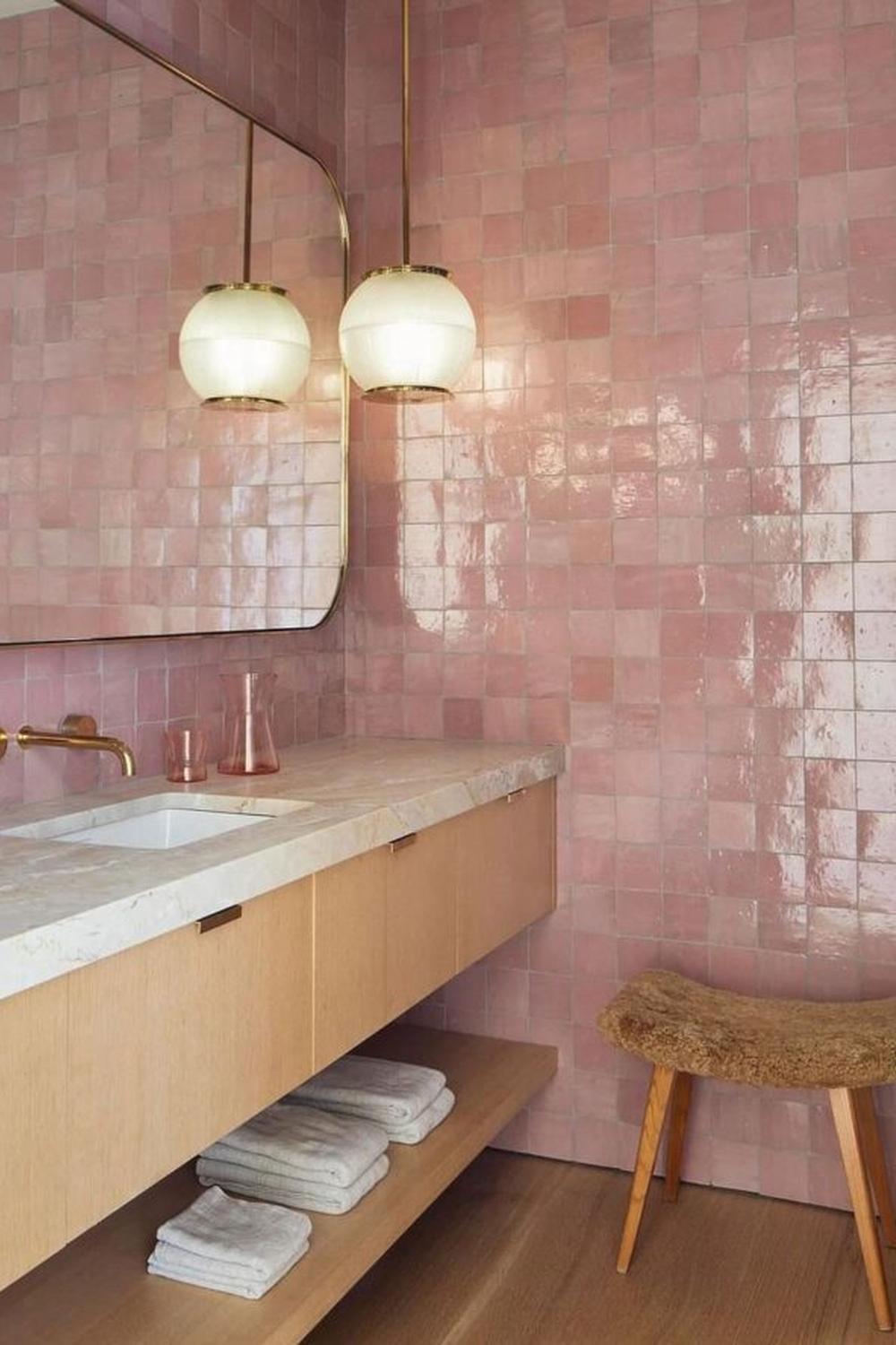Baño elegante con azulejos rosas que crean una atmósfera cálida.
