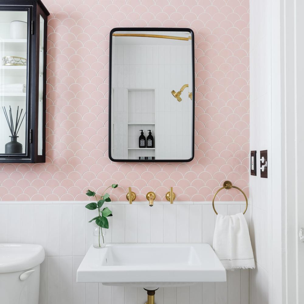 Baño con azulejos rosas que destacan en un diseño contemporáneo y juguetón.