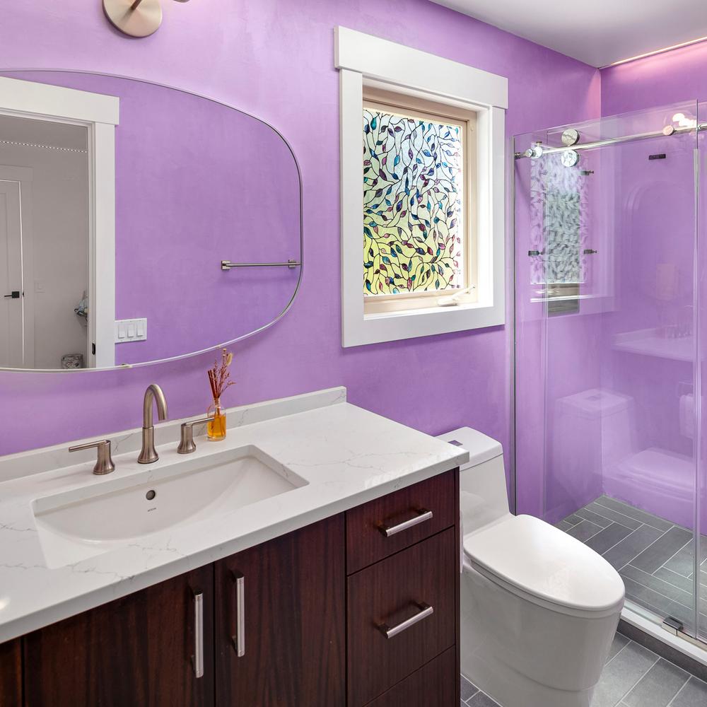 Contemporary bathroom with light purple paneled walls and a stylish vanity.